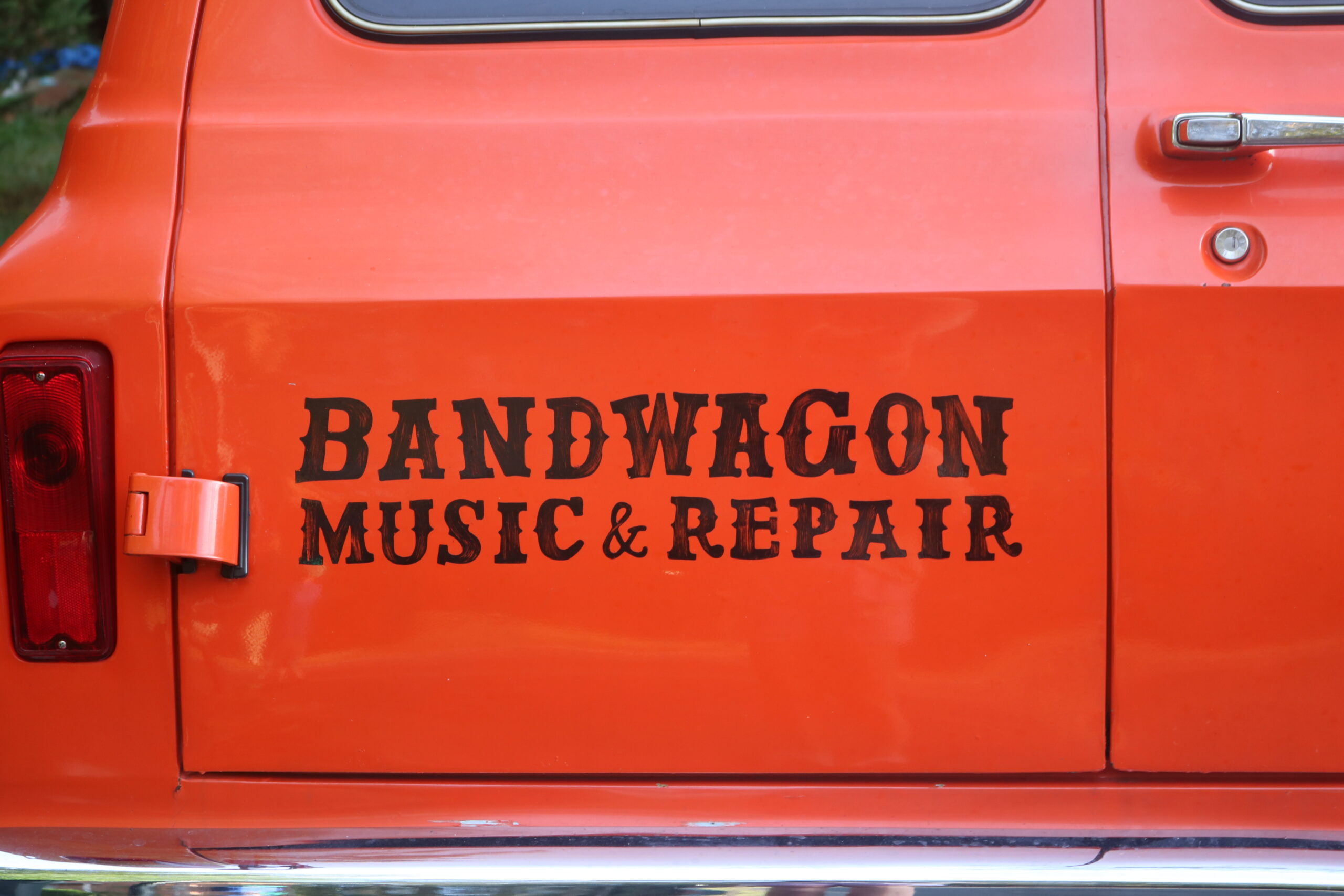 Bandwagon Music and Repair logo on a red van