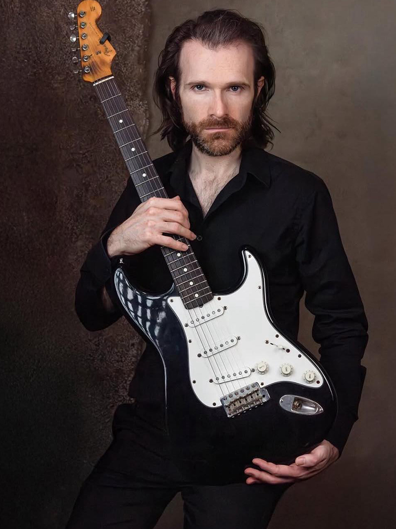 Tristan holding a guitar